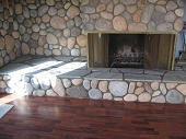 Eldorado river stone veneer fireplace with raised flagstone hearth cap