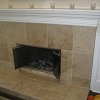 Travertine Tiled Face Fireplace and raised hearth - custom wood mantel