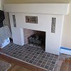 Plaster Fireplace with decorative tile inlays and tiled hearth